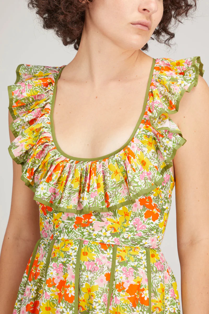 Woman in a floral dress. Showing the top frilly collar 