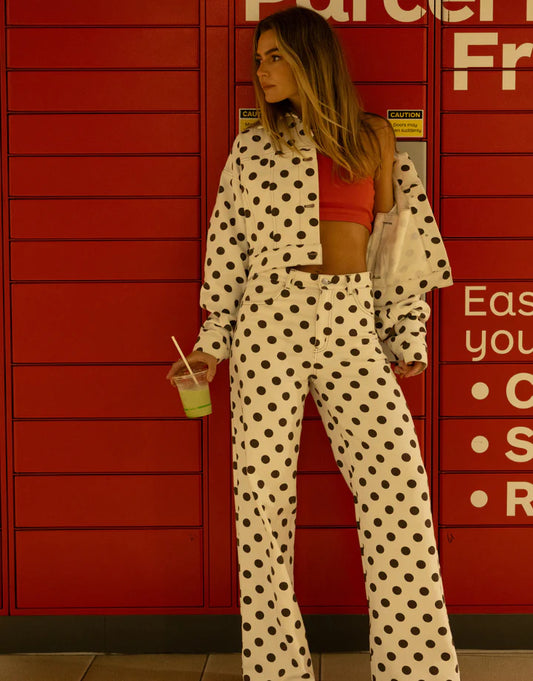 Woman in polka dot outfit standing in front of red lockers